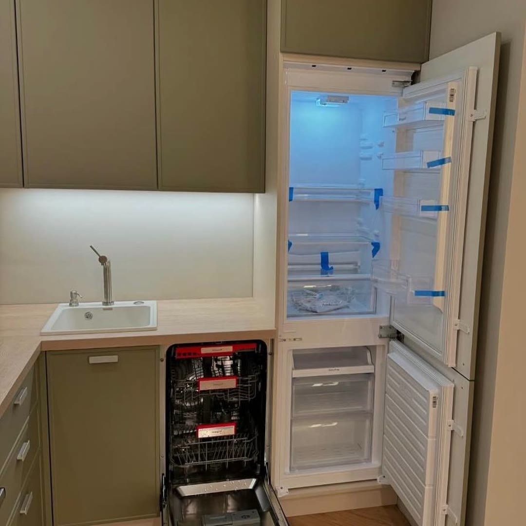 The same kitchen with the integrated fridge-freezer and dishwasher doors open